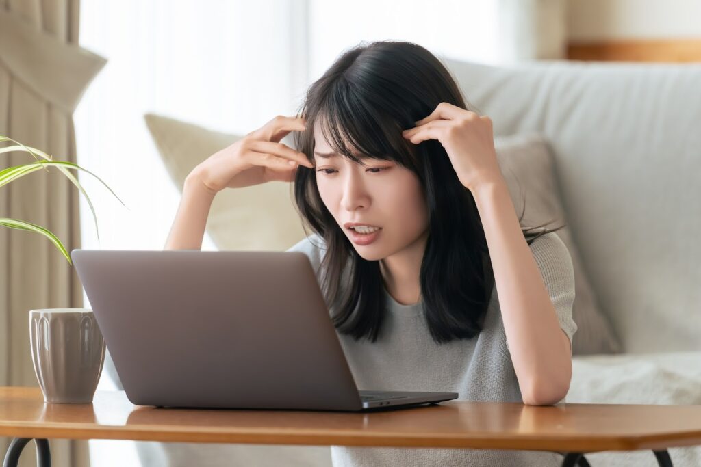 失敗して頭を抱えている女性画像